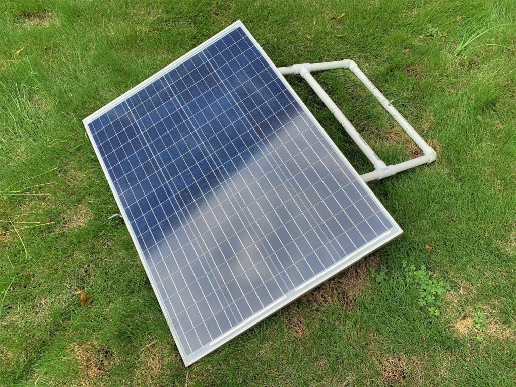 A solar panel mounted in a field on a sunny day