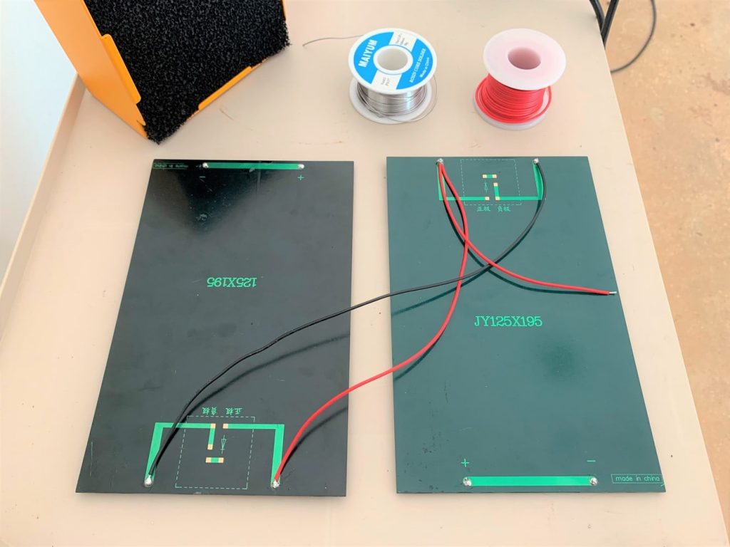 Two solar panels wired in parallel with a red lead