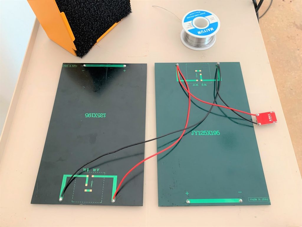 Two solar panels wired to a 5-volt USB buck converter