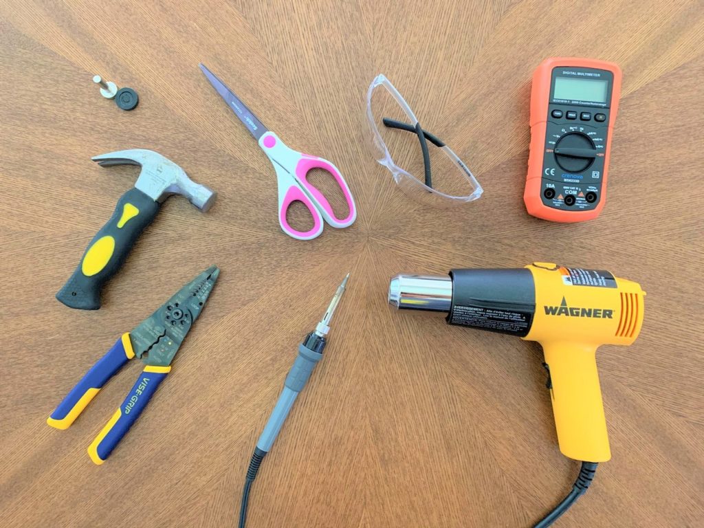 Tools for building a DIY solar USB charger laid out on a wooden table