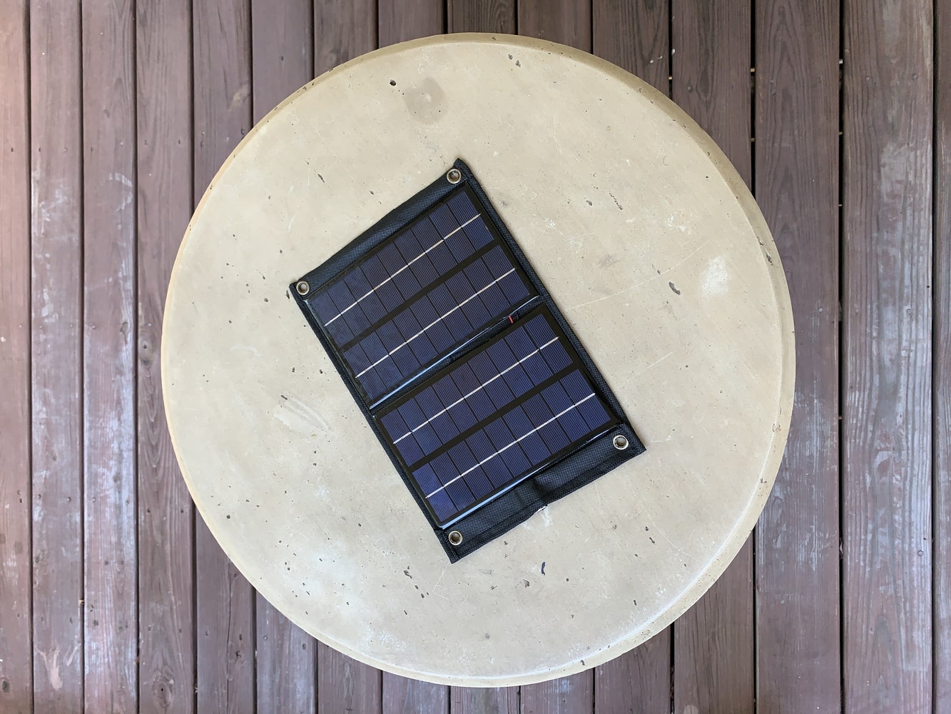 A DIY solar charger resting on a table on a balcony
